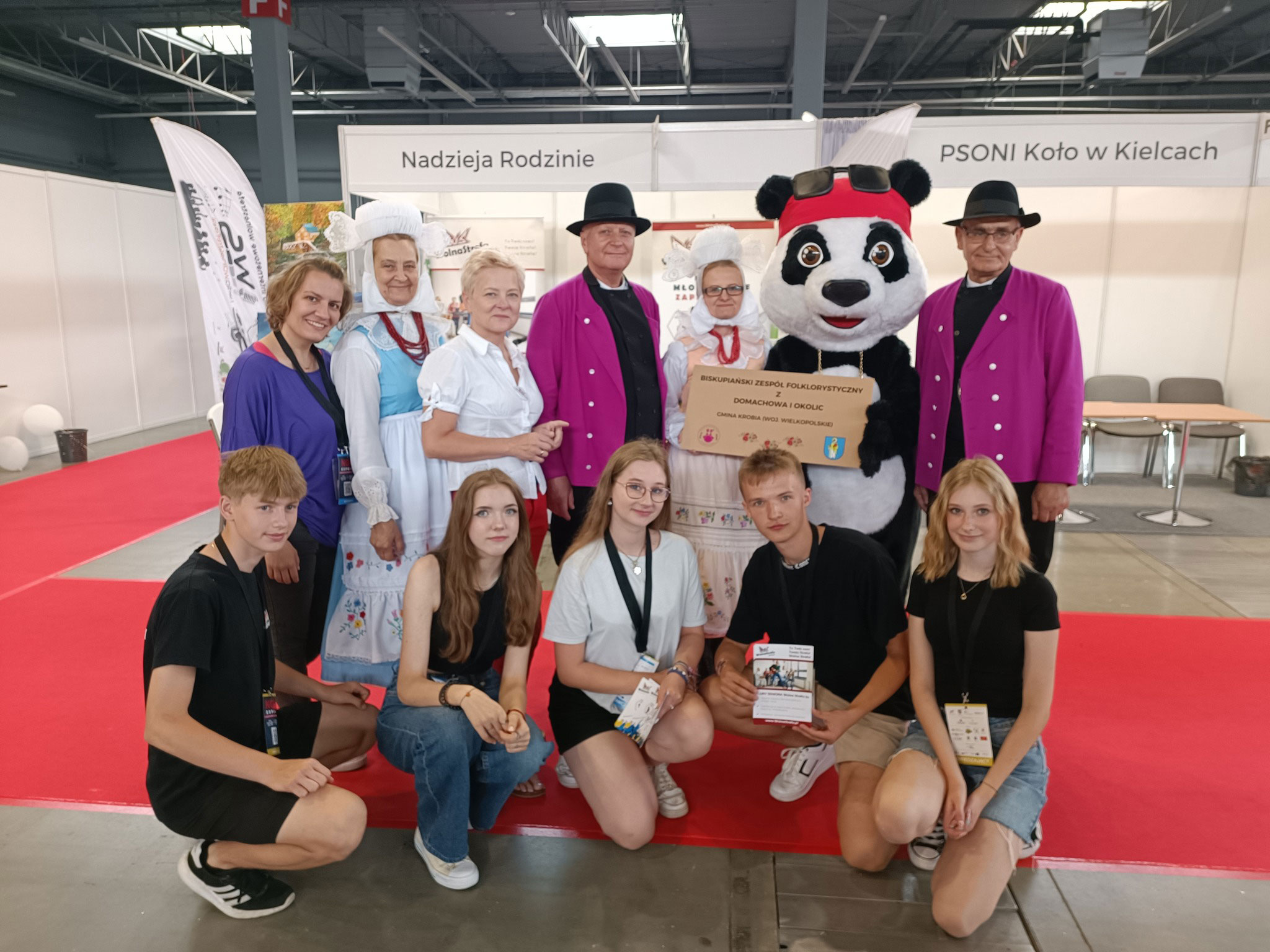 Na fotografii widnieje strój reklamowy w postaci misia pozujący do zdjęcia w siedzibie firmy Elabika